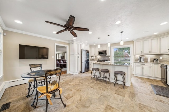 kitchen featuring pendant lighting, appliances with stainless steel finishes, light stone counters, a center island, and a breakfast bar area