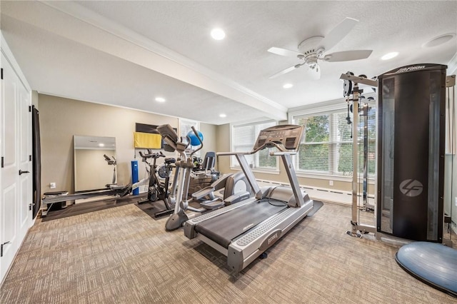 workout area featuring a textured ceiling, carpet flooring, ceiling fan, and ornamental molding