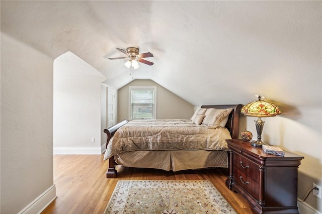 bedroom featuring ceiling fan, lofted ceiling, and light wood-type flooring