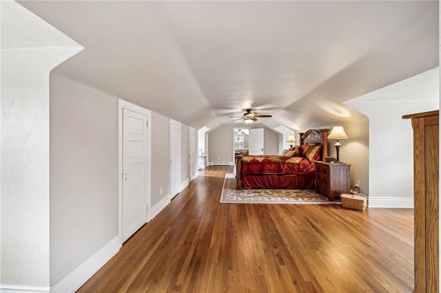 bedroom with ceiling fan, wood-type flooring, and vaulted ceiling