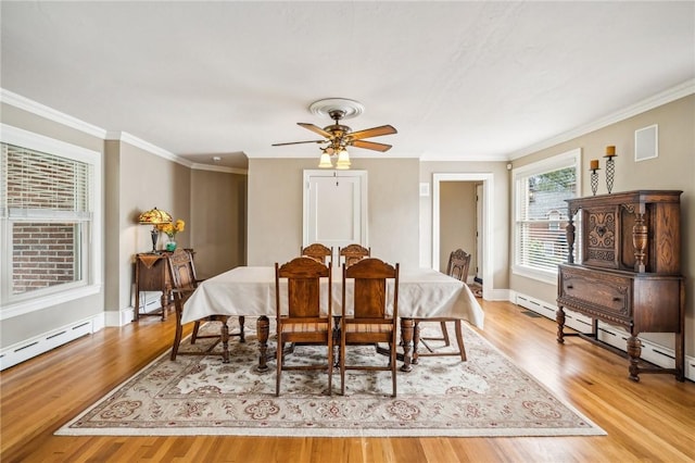 dining space with ceiling fan, a baseboard radiator, ornamental molding, and light wood-type flooring