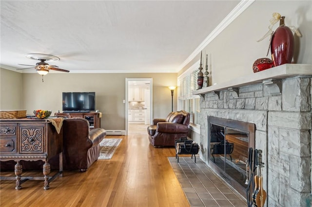 living room with crown molding, baseboard heating, wood-type flooring, and a fireplace