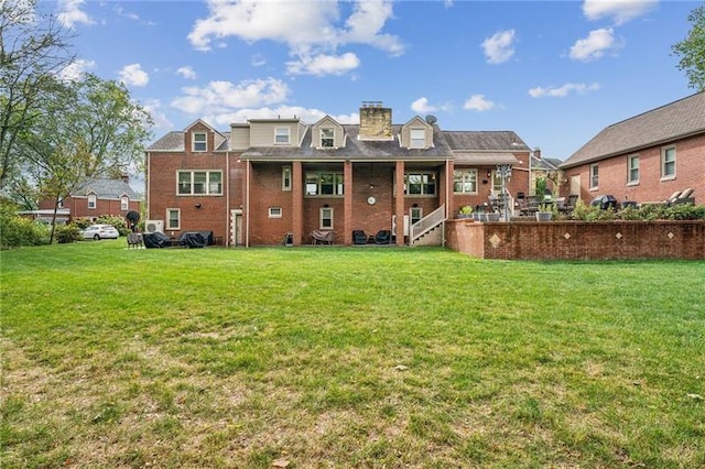 rear view of property with a yard