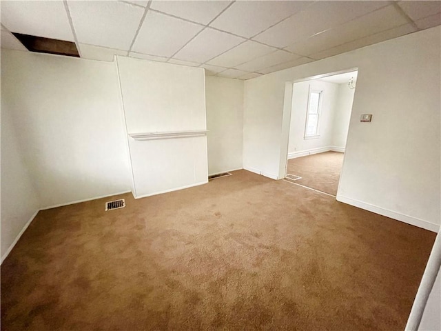 carpeted empty room with a paneled ceiling