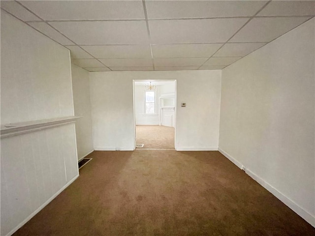 carpeted spare room with a drop ceiling