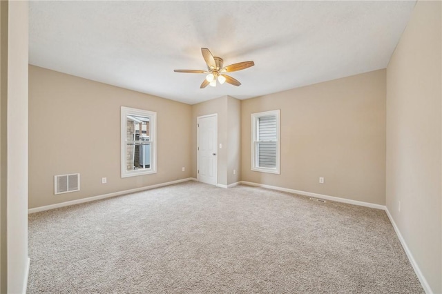 empty room featuring light colored carpet and ceiling fan