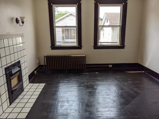 unfurnished living room featuring radiator heating unit and a tile fireplace