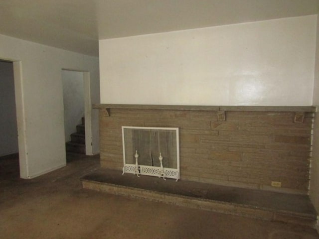 unfurnished room featuring a brick fireplace