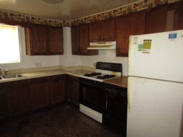 kitchen featuring sink, gas stove, and white fridge