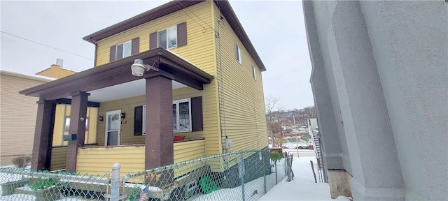 view of snowy exterior with covered porch