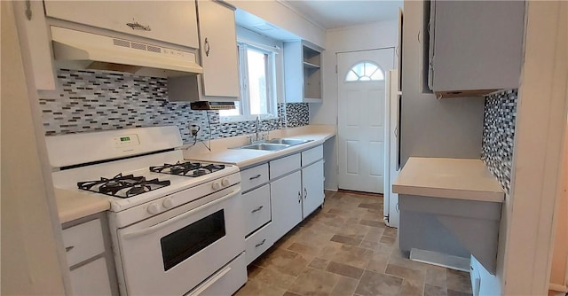 kitchen with white gas range, sink, decorative backsplash, and white cabinets