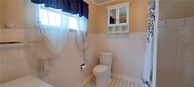 bathroom featuring toilet, tile patterned floors, and tile walls