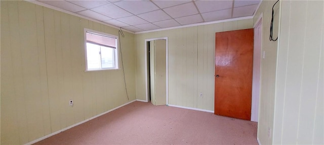 unfurnished bedroom featuring light colored carpet and a drop ceiling