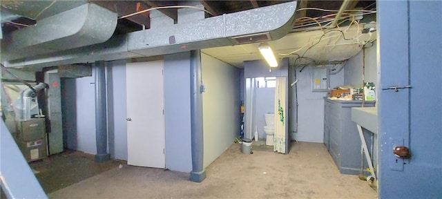 basement featuring electric panel and heating unit