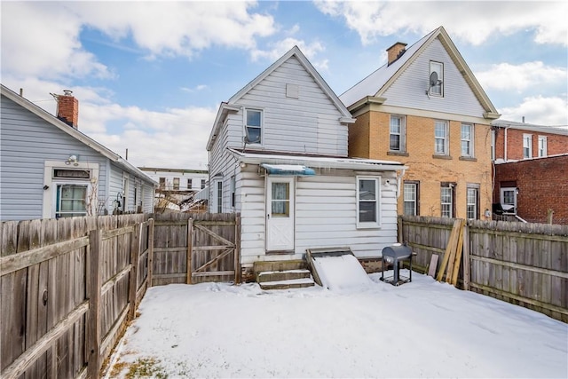 view of snow covered rear of property