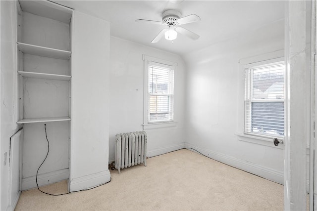 bedroom with ceiling fan, light colored carpet, radiator, and vaulted ceiling