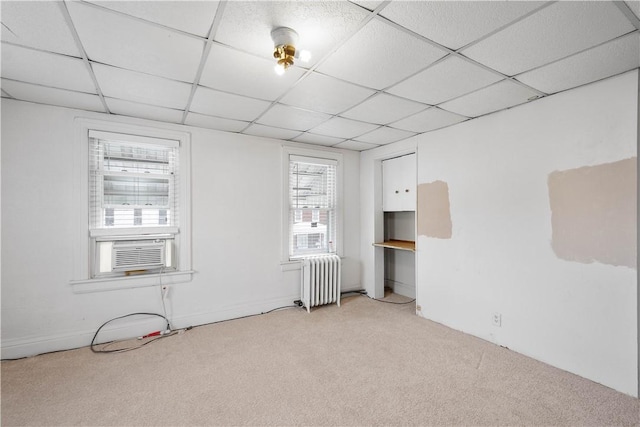 unfurnished room with radiator heating unit and light colored carpet