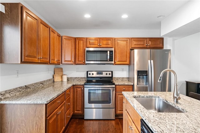 kitchen featuring sink, light stone countertops, appliances with stainless steel finishes, and dark hardwood / wood-style flooring