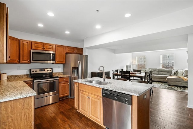 kitchen with sink, a center island with sink, dark hardwood / wood-style flooring, and stainless steel appliances