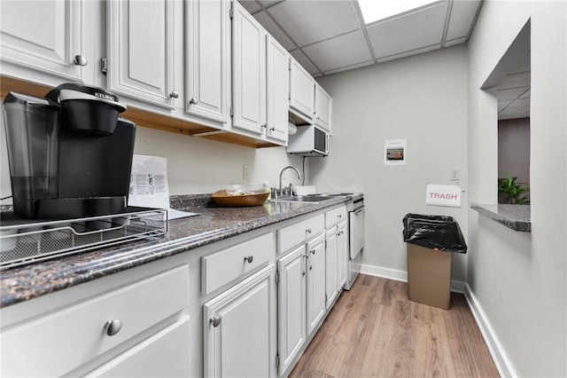 kitchen with sink, white cabinetry, and a drop ceiling