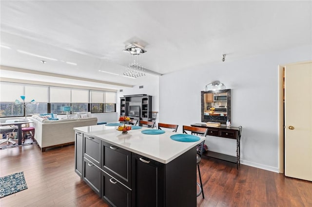 kitchen featuring a center island, a breakfast bar area, and dark hardwood / wood-style flooring