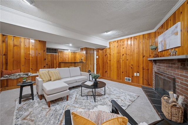 living room featuring carpet, a brick fireplace, ornamental molding, and a textured ceiling