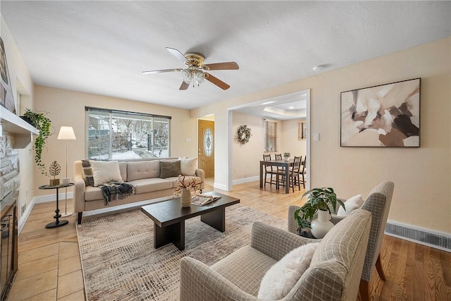 living room with ceiling fan, light tile patterned floors, and a fireplace