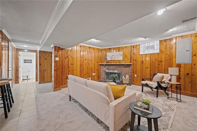 living room with a textured ceiling, a fireplace, ornamental molding, electric panel, and light tile patterned flooring