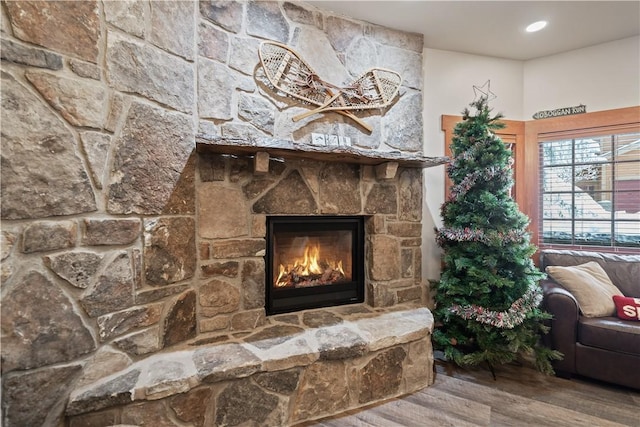 interior details featuring a stone fireplace and hardwood / wood-style floors