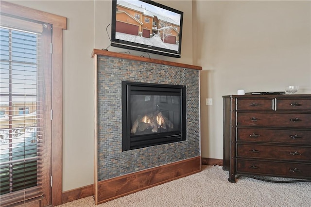 details featuring a tile fireplace and carpet flooring