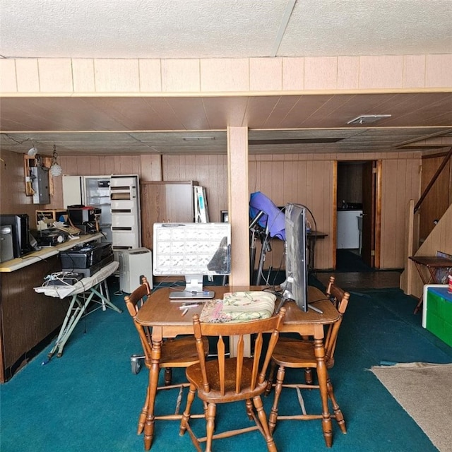 dining space with carpet, electric panel, washer / dryer, and wood walls