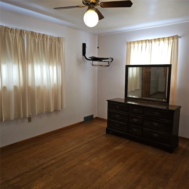 unfurnished bedroom with ceiling fan and dark hardwood / wood-style flooring