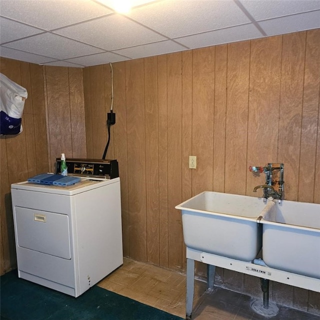 washroom featuring sink, wood walls, and washer / clothes dryer