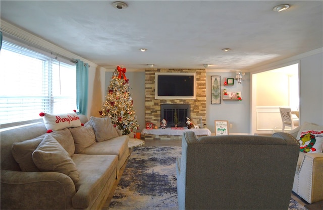 living room with crown molding and a fireplace