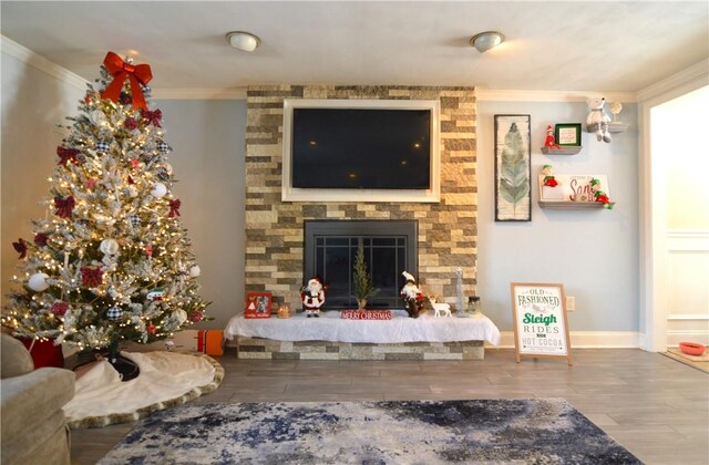 living room with hardwood / wood-style floors, crown molding, and a fireplace