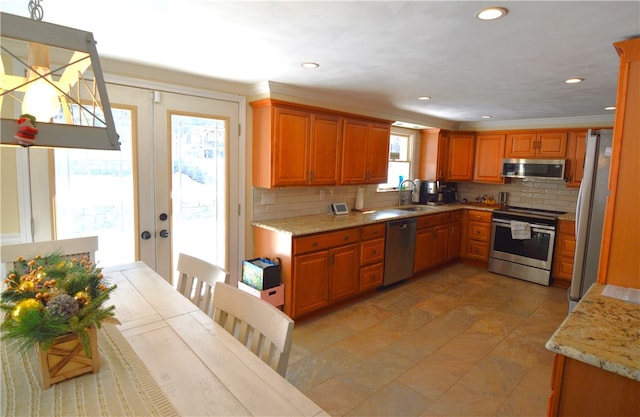 409 Himler Rd, Hempfield Twp Wml, PA 15601 - kitchen featuring appliances with stainless steel finishes, a sink, decorative backsplash, brown cabinetry, and light stone countertops