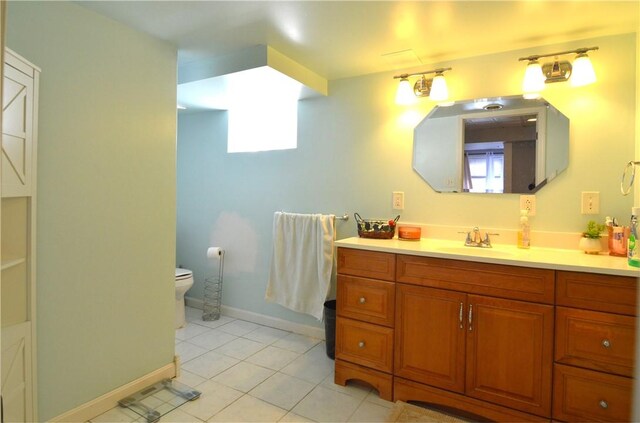 bathroom featuring vanity, tile patterned floors, and toilet