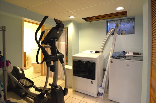 exercise area featuring separate washer and dryer and light tile patterned floors