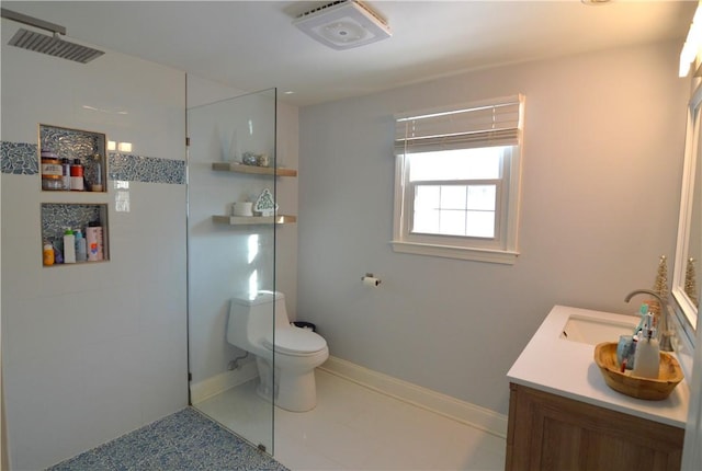 bathroom featuring vanity, tiled shower, tile patterned floors, and toilet