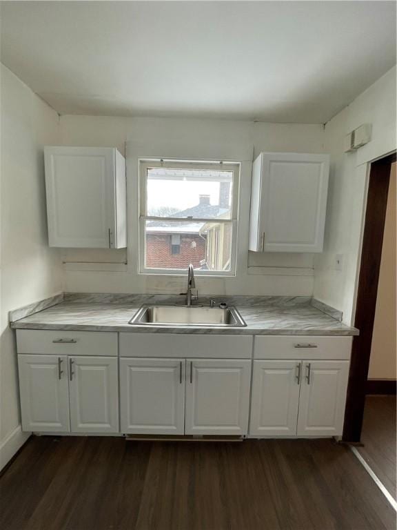 kitchen with sink, white cabinets, and dark hardwood / wood-style floors