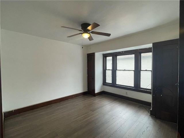 unfurnished room featuring dark hardwood / wood-style floors and ceiling fan