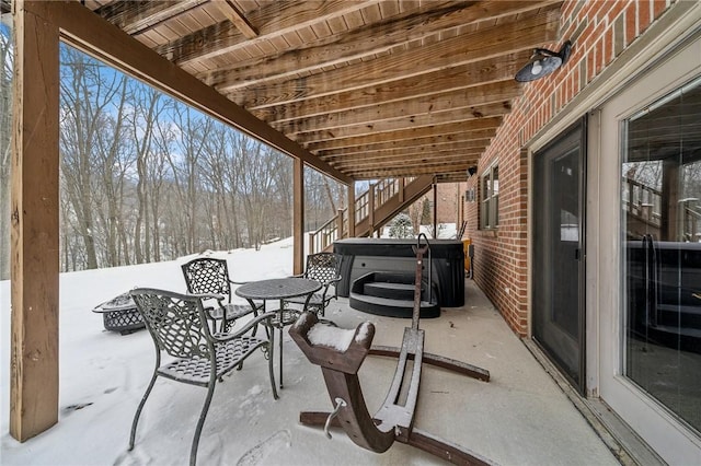 snow covered patio with a hot tub