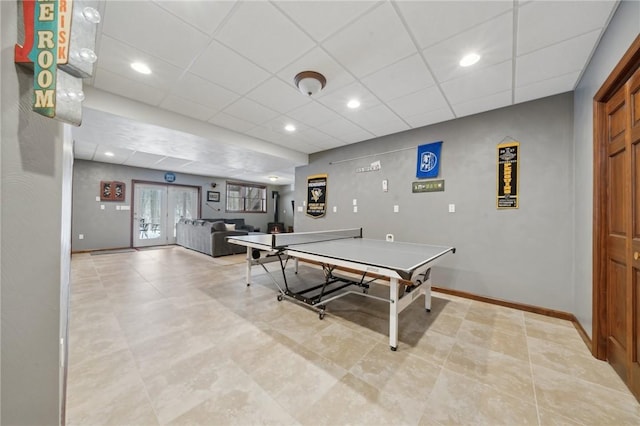 game room with a paneled ceiling