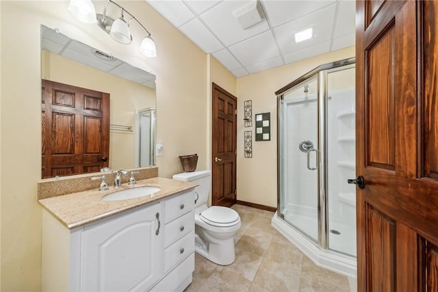 bathroom featuring a shower with shower door, toilet, tile patterned flooring, a drop ceiling, and vanity