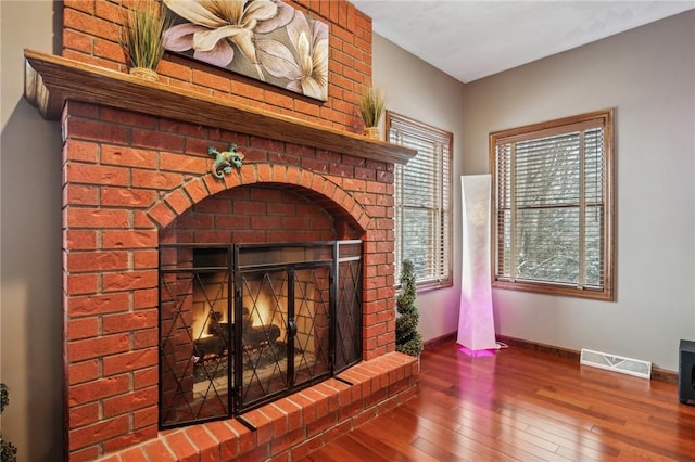 interior details with hardwood / wood-style flooring and a brick fireplace