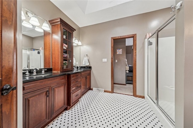 bathroom featuring a shower with shower door and vanity