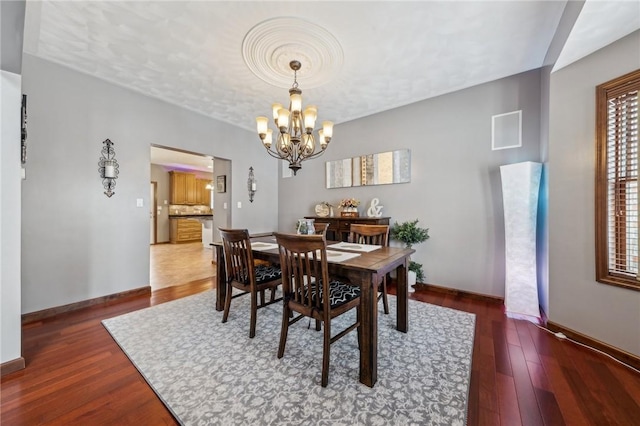 dining room featuring dark hardwood / wood-style floors and an inviting chandelier