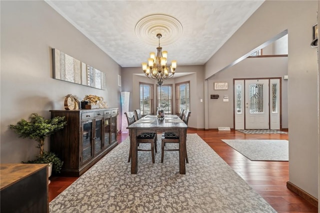 dining area with a notable chandelier and dark hardwood / wood-style flooring