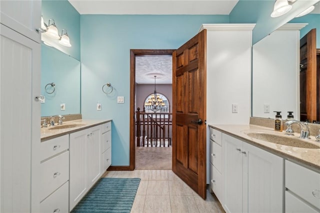 bathroom featuring tile patterned floors, a notable chandelier, and vanity