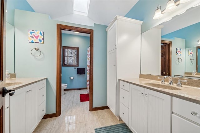 bathroom with vanity, toilet, and a skylight